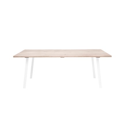 A stylish natural oak dining table with white iron legs