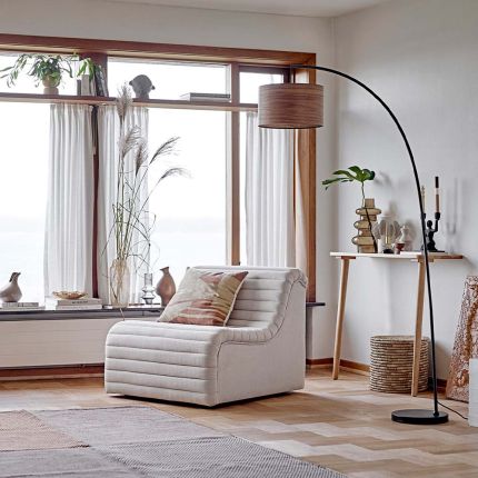An elegant floor lamp with a curved arm and a hanging wooden shade