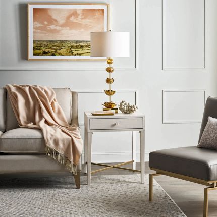White wooden bedside table with brass accent