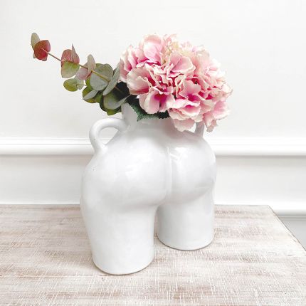 a white vase featuring a feminine bottom