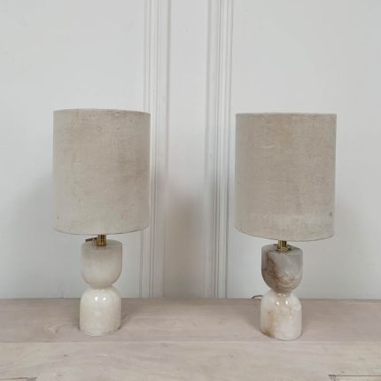 Luxurious, hourglass-shaped alabaster table lamps with dented cotton lampshades