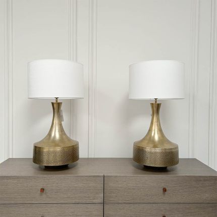 An elegant antique brass engraved table lamp with an off-white shade