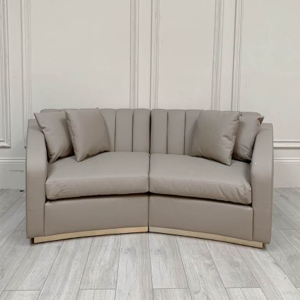 Stylish curved sofa with cobble leather upholstery and brass plinth base