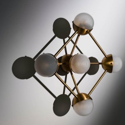 Elegant brass wall fixture with five frosted orb shades and geometric appeal