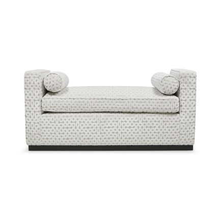 A luxurious bench with a seat cushion and bolster cushions 