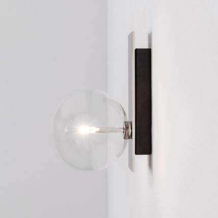 An elegant black gunmetal wall lamp with a transparent glass lampshade