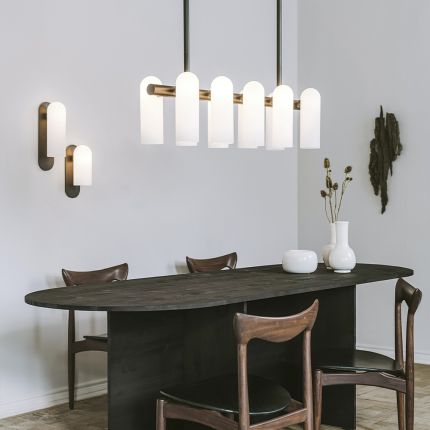 A luxurious linear chandelier by Schwung featuring translucent glass shades hung from a beautiful brass frame