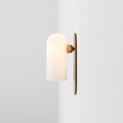 Natural brass finish wall lamp with a long translucent glass globe