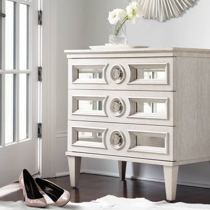 An alluring white oak veneer bedside table by Bernhardt with antique mirrored glass panels, Silver Luster highlights and a Manor White finish