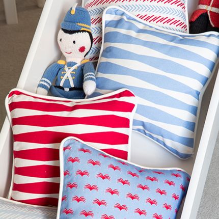 A bright and beautiful red children's cushion with a unique and playful pattern  