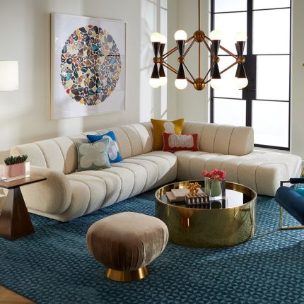 A sumptuous sectional sofa by Jonathan Adler upholstered in an Olympus Ivory bouclé with stylish deep channelled cushions and capsule-shaped arms