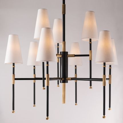 An elegant aged old bronze chandelier with multiple linen lampshades