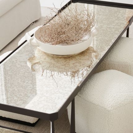 A gothic-inspired coffee table with an antique mirrored surface