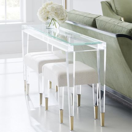 A contemporary console table crafted from clear acrylic with gold capped feet
