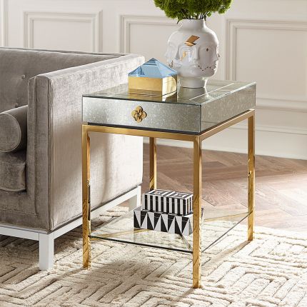 An elegant mirrored side table with a polished brass frame 