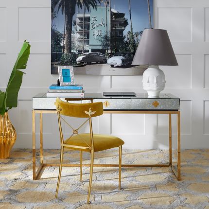 A glamorous, modern desk with a antiqued mirror table top and a polished brass base