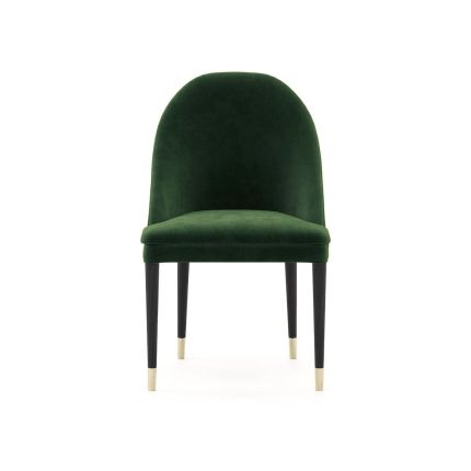 A contemporary velvet dining chair with dark brown legs and golden caps