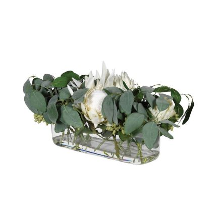eucalyptus and protea floral arrangement in clear, rectangular vase