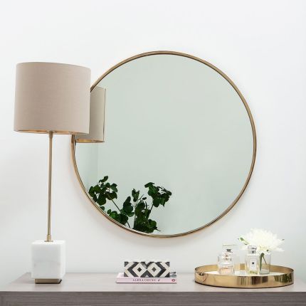 A luxury round mirror with a gold finish 