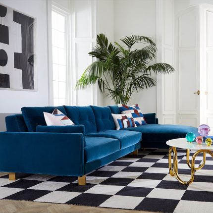 A mesmerising, deep blue corner sofa with brushed brass feet