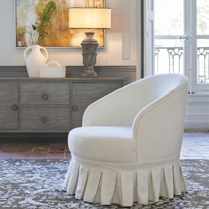A luxurious, French-style off-white cotton and linen blend armchair with pleated fringing
