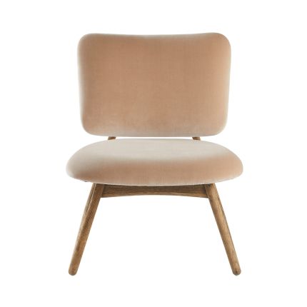 A luxurious nude beige velvet armchair with a natural oak wood frame