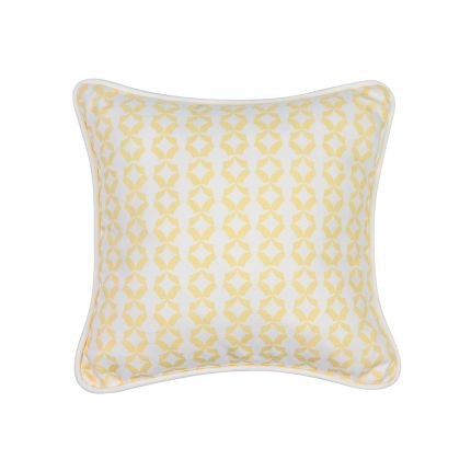A bright yellow cushion with white piping and a playful abstract pattern