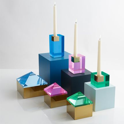 A glamorous candleholder by Jonathan Adler featuring a blue acrylic block fitted with a solid brass candleholder