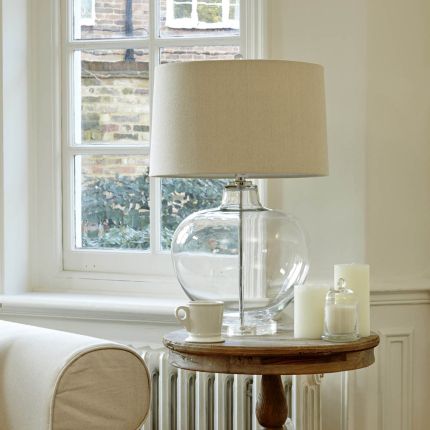 Striking round glass side lamp with wide linen shade