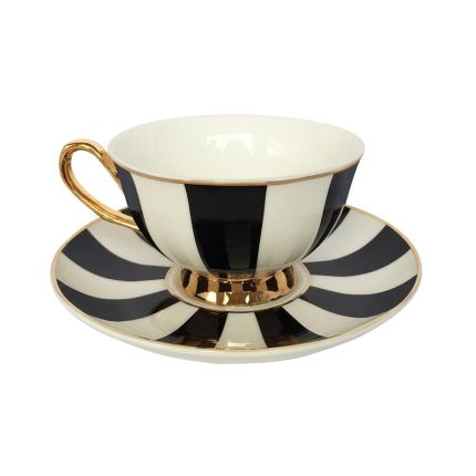 Glamorous teacup and saucer in black and white with brass details
