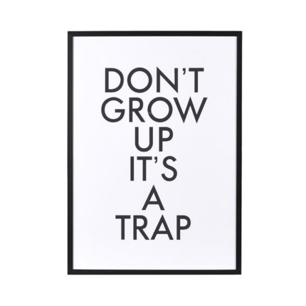 'Don't grow up, it's a trap' art print in a black frame.
