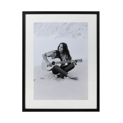 Black and white print of Joan Baez with guitar on the beach