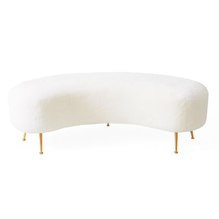 A luxurious natural shearling upholstered bench with angled brass legs