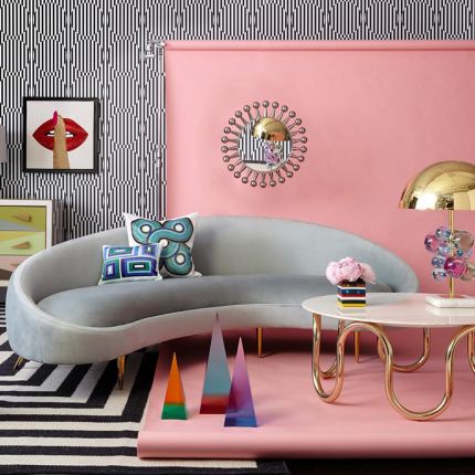 A contemporary, curved sofa with velvet upholstery and golden legs