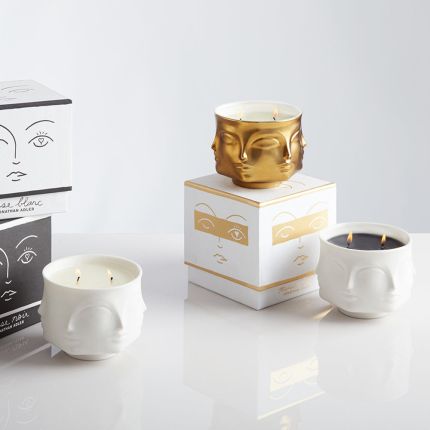 Golden ceramic candle by Jonathan Adler with faces 