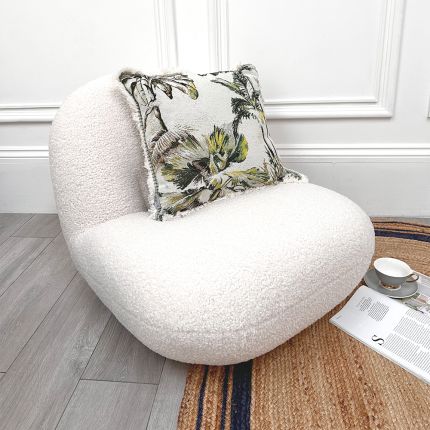 A luxury low boucle accent chair with a stylish brass base