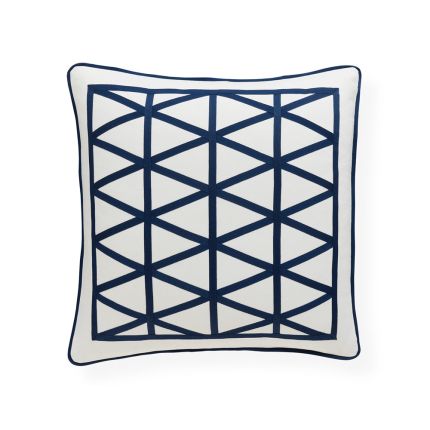 A stylish cushion by Jonathan Adler with a pattern formed from navy, raised ribbon embroidery on a ivory cover