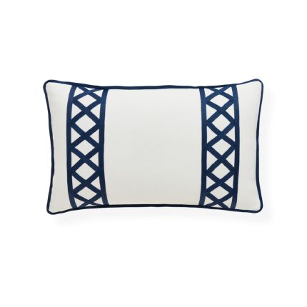A stylish, rectangular outdoor cushion by Jonathan Adler with an ivory cover and navy raised grosgrain ribbon embroidery