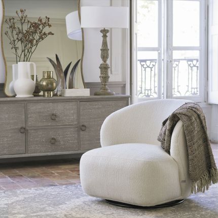 A luxurious armchair with a sumptuous upholstery and stylish swivel base