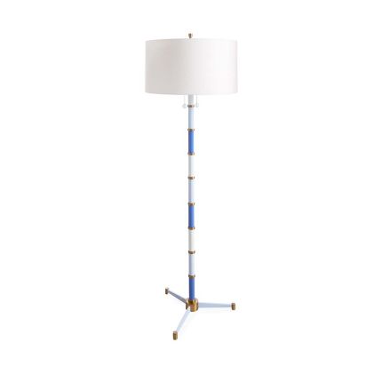 A blue-hued three footed floor lamp with pull strings, brass elements and a white shade.
