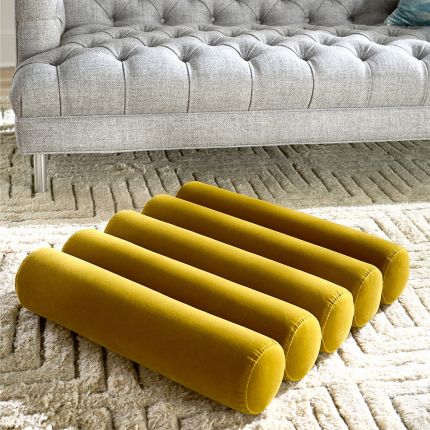 A luxury floor cushion with a channelled design and yellow velvet finish 