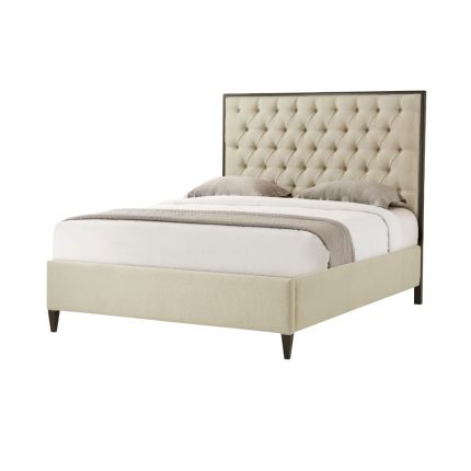 A stunning bed from Theodore Alexander with a neutral, deep-buttoned headboard and a dark solid beech frame