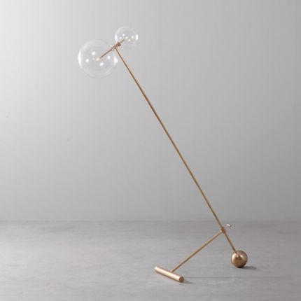 Natural brass industrial style floor lamp with angled design and clear glass globe lampshades with adjustable height