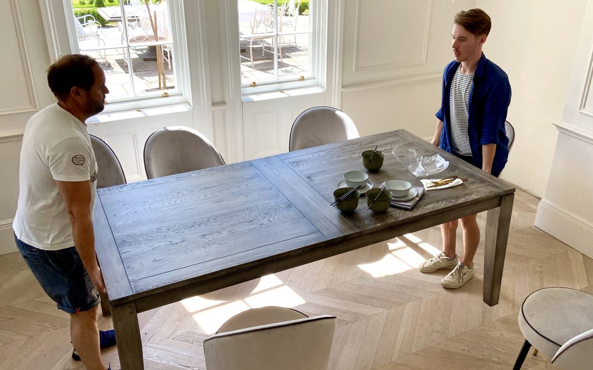 two men lifting a luxurious dining table