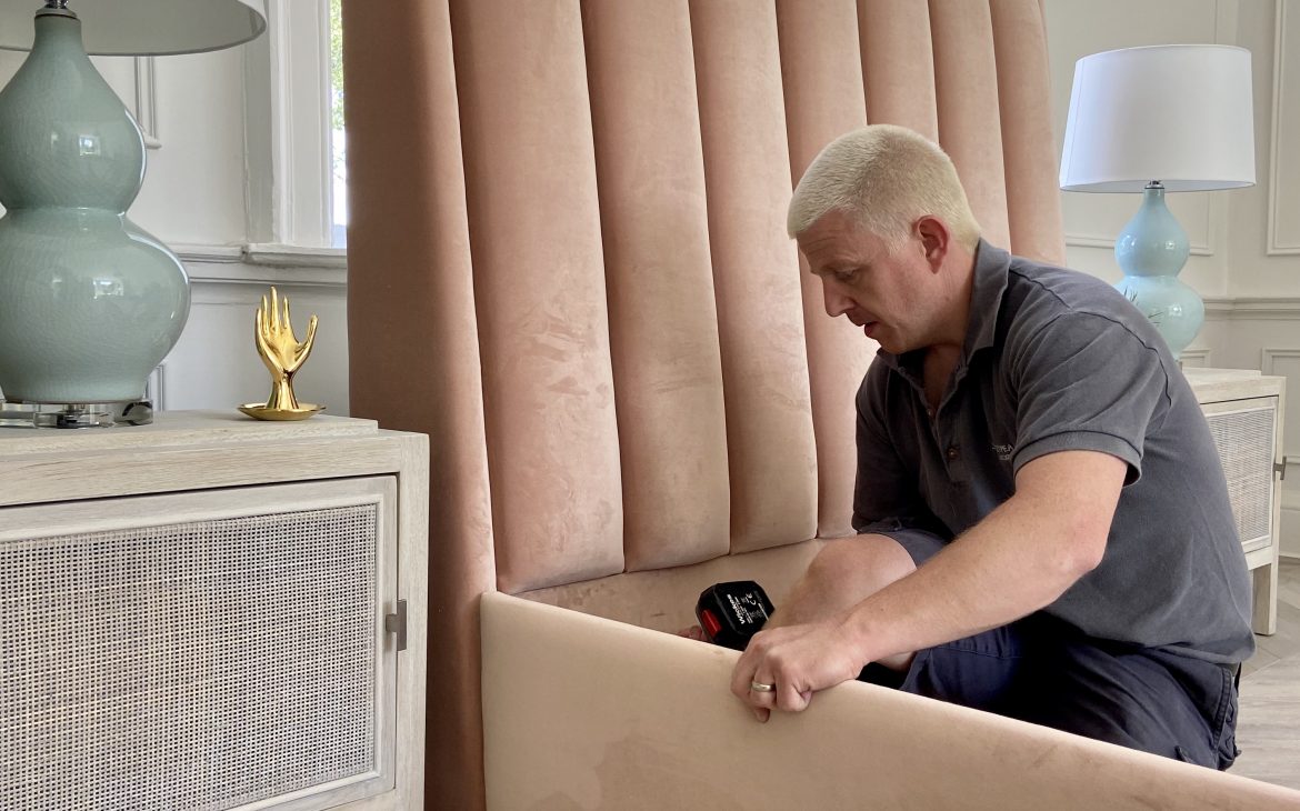 a man assembling a stylish pink bed