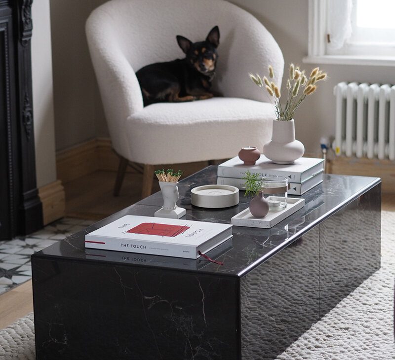 a stylish black marble table in a minimalist living room